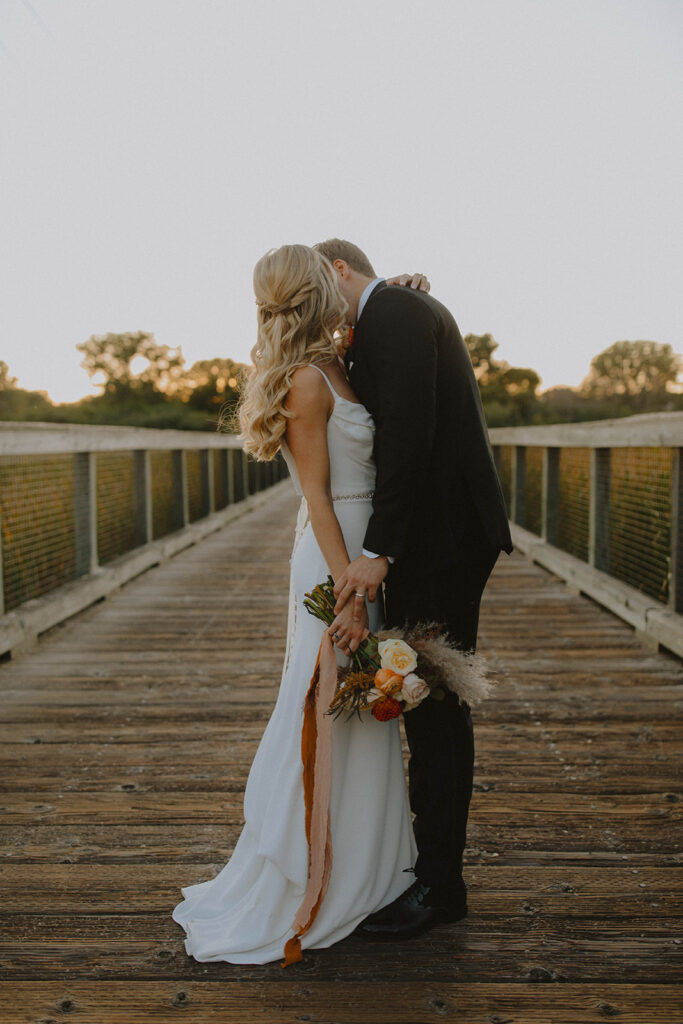 bride and groom at sunset looking at each other and smiling for the wedding photography narrative